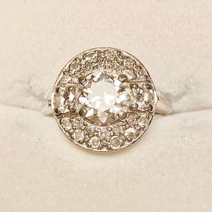 "Cartier" with a center prong Old European Cut accented with smaller diamonds.